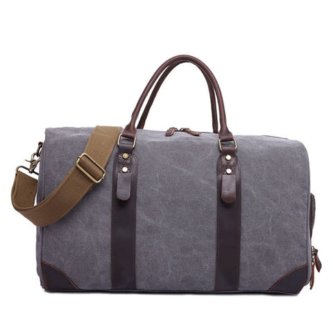 Grey genuine leather overnight bag with large compartments, zippered pockets, adjustable shoulder strap with buckle detail and sturdy top handles