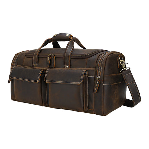Brown high-quality top-grain genuine leather duffel bag with large inner compartments and adjustable shoulder strap with buckle detail and sturdy top handles