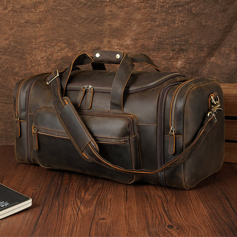 Dark brown top grain leather duffel travel bag with large inner compartment and many zippered pockets.