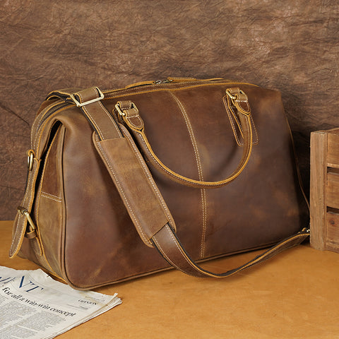 Brown top-grain genuine leather travel or gym bag with large inner compartments and adjustable shoulder straps.