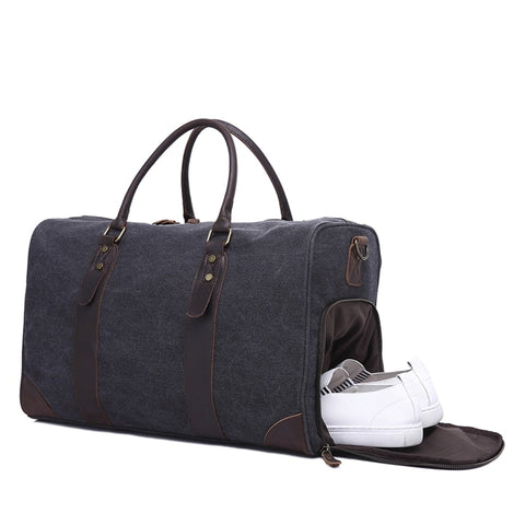 Dark grey genuine leather overnight bag with large compartments, zippered pockets, shoe compartment, adjustable shoulder strap with buckle detail and sturdy top handles